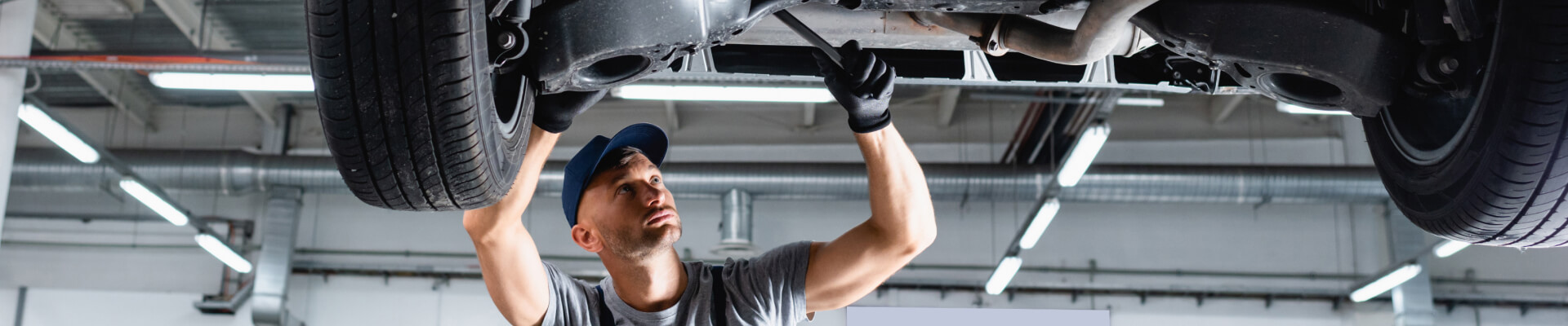 Service employee working on the undercarriage of a vehicle